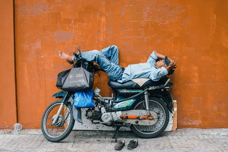 バイクの上で昼寝をする男性